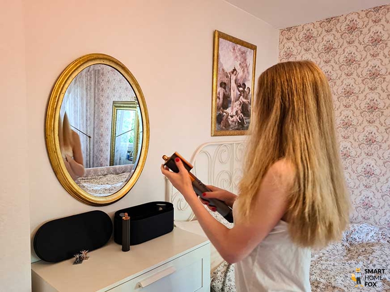 Женщина держит в руках Dyson Airwrap.